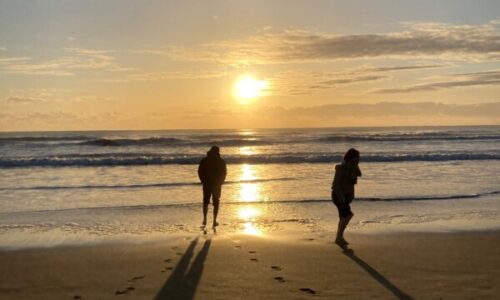 海岸で朝日を浴びている子供たち